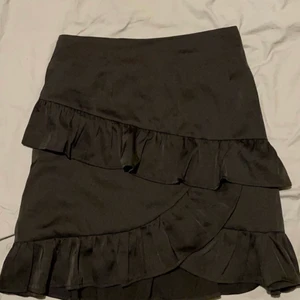 Svart kjol med volanger - Superfin kjol med volanger både bak och fram. Säljer då den inte kommer till användning längre.