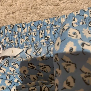 kort blå kjol, storlek S - En kort blå kjol med vita blommor på,använt ungefär tre gånger så kjolen är fortfarande i väldigt bra skick.