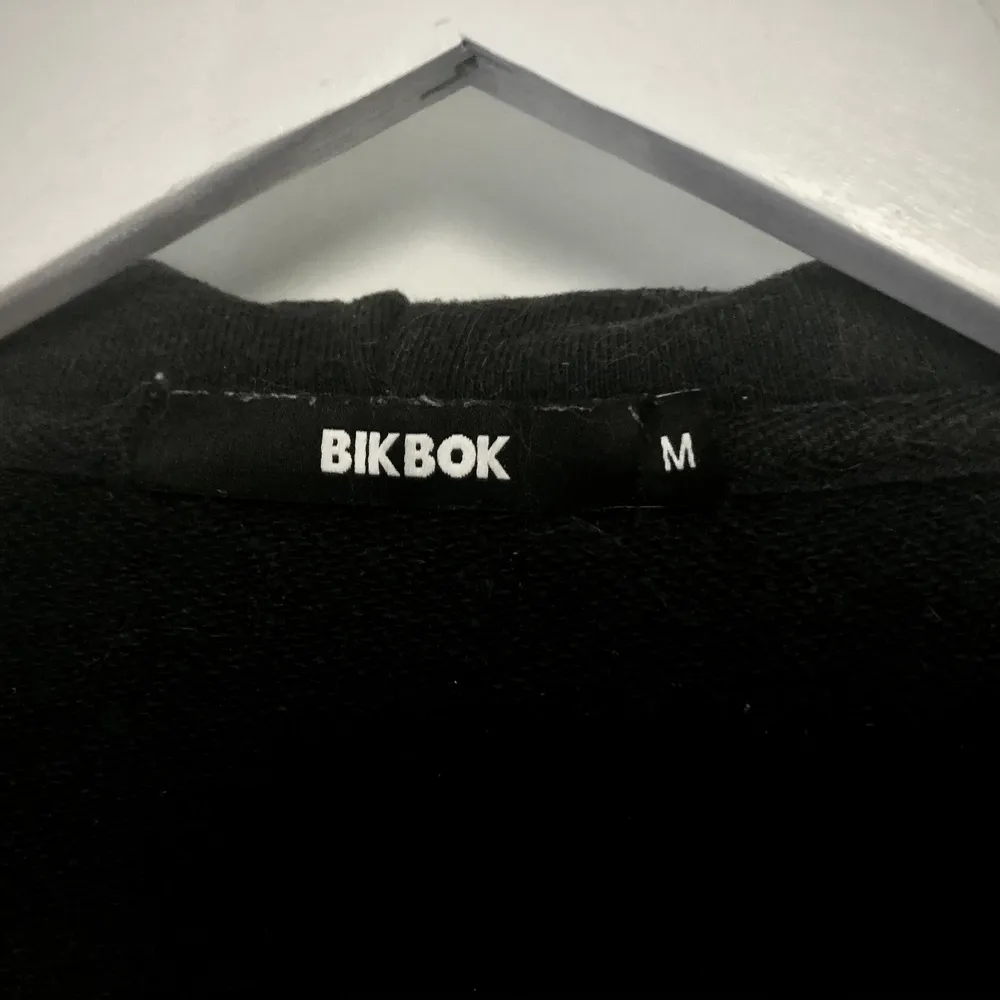 Midjekort, svart, hoodie från Bik Bok säljes på grund av att jag äger alldeles för många tjocktröjor! Katt finns i hemmet!. Hoodies.