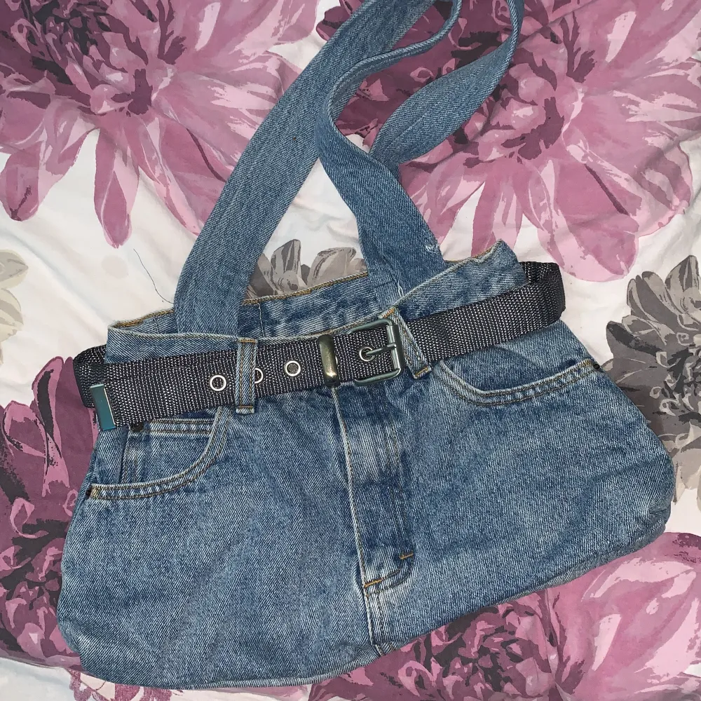 Jeans tyg med extra fickor, bälte runt, blå och gullig. Väskor.