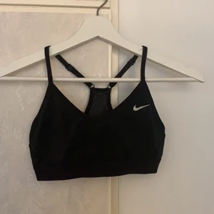 Nike sporttopp  - En svart fin Nike sporttopp som är använd men i fint skick. Lite sprickor på Nike tecknet, men inget man tänker på mycket. Superskön att ha när man tränar och även under en vanlig tröja. Säljer pågrund av för liten🤍 Hör av er för fler bilder eller frågor🤍 