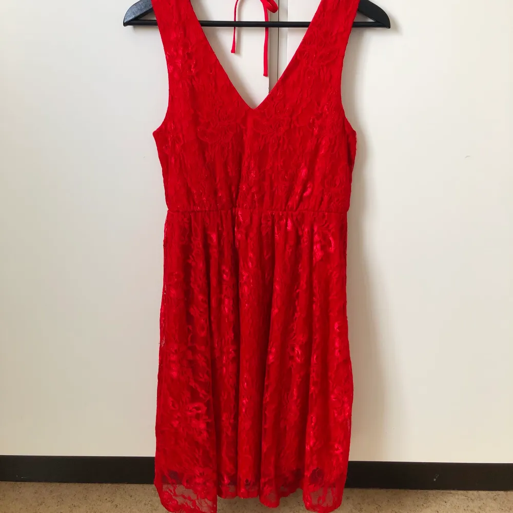 Röd knälång klänning i spets med djup rygg från Jeane Blush.. Klänningar.