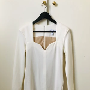 Cremefärgad klänning  - Cremefärgad knälång figurnära klännning från NLYTrend.