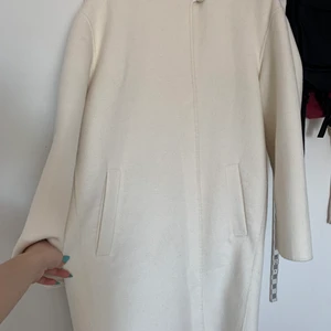 Kappa  - Huvad ylle-blandad rock Lång design. Ostrukturerad design. Ylleblandat tyg. Huva. Lång ärm. Två fickor på sidorna. Knappfäste på nacken. Knappar med sköldpaddsmönster.                                                   Jag har använda bara 2 gånger. Förra år köpa jag 1000kr. Nu sälja jag 700kr. 