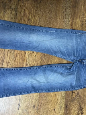 Blå raka jeans med tvättade detaljer - Säljer ett par klassiska blå jeans med raka/ utsvängda ben (storlek är s tror jag) och snygga tvättade detaljer på låren och knäna. Jeansen har en tidlös look och passar perfekt till en avslappnad stil. Materialet är denim i bomull och de har low normal midja. 