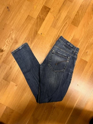 Mörkblå dondup George jeans med sjuka slitningar! - Säljer ett par mörkblå dondup George jeans med slitningar. Jeansen har klassisk femficksdesign, Materialet är stretchigt denim för en bekväm passform. Perfekta för en avslappnad och trendig look.               Tveka inte på att ställa frågor! Fraktar snabbt✅ 