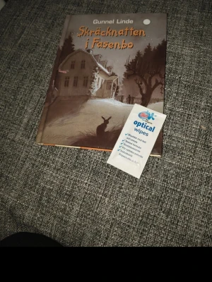 Skräcknatten i Fasenbo av Gunnel Linde - En spännande skönlitterär bok med titeln 'Skräcknatten i Fasenbo' av Gunnel Linde. Omslaget är mörkt med illustration av ett gammalt hus, träd och en hare i förgrunden, vilket ger en mystisk och kuslig känsla.