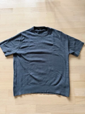 Grå ribbad t-shirt Massimo Dutti - Snygg grå t-shirt från Massimo Dutti i ribbad bomullsmix. Modellen har rund halsringning och korta ärmar. Perfekt för en avslappnad men stilren look.