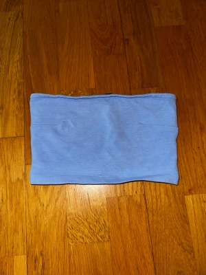 Ljusblå bandeau tubtopp Ginatricot - Säljer en ljusblå bandeau tubtopp från Ginatricot. Toppen är axelbandslös och har en enkel, clean design i mjuk bomullsmix. Perfekt att styla med höga jeans eller kjol för en chill look.