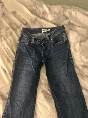 Mörkblå bootcut jeans från 157 - Snygga mörkblå bootcut jeans från 157 med klassisk femficksdesign och låg midjade Jeansen har en lätt tvättad look och är tillverkade i denim med stretch för extra komfort. Perfekta för en avslappnad och trendig stil. Helt nya 