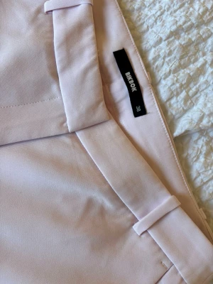 Rosa flared kostymbyxa från Bik Bok - Säljer ett par ljusrosa kostymbyxor från Bik Bok, modell Vera Flared. Byxorna har utsvängda ben, hällor för skärp och en stilren look. Perfekta för dig som vill ha en trendig och bekväm byxa med snygg passform. Dom har blivit använda 2 gånger och säljer för att jag inte har behov av dom mer💗