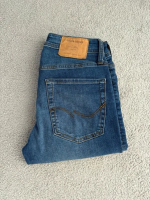 Blå jeans från Jack & Jones - Snygga blå jeans från Jack & Jones i slim fit/glenn.   Storlek: W27 L32 || Mörkblå || SlimFit/Glenn