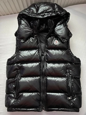 Moncler väst - Säljer en Moncler-väst i storlek S, inköpt sommaren 2025 och endast använd i cirka 2 månader. Västen är i mycket fint skick och har hanterats väldigt varsamt, vilket gör att den knappt ser använd ut. Den säljs enbart eftersom den tyvärr inte passar mig längre nu när jag testade den igen inför den varmare säsongen. QR-kod, serialnummer och tags finns kvar. Kvitto saknas tyvärr då det har kommit bort. Pris kan diskuteras vid snabb och seriös affär.