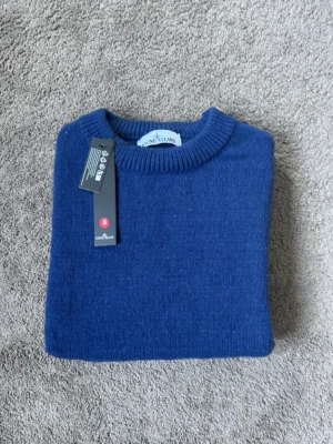 Mörkblå stickad tröja Stone Island - Mörkblå stickad tröja från Stone Island med klassisk rund halsringning och ribbade muddar. Tröjan har den ikoniska loggan på vänster ärm. Passar perfekt till dig som vill lägga till en extra tutch. Storlek S, Helt ny. Vid frågor eller funderingar tveka inte på att skriva mvh 😁