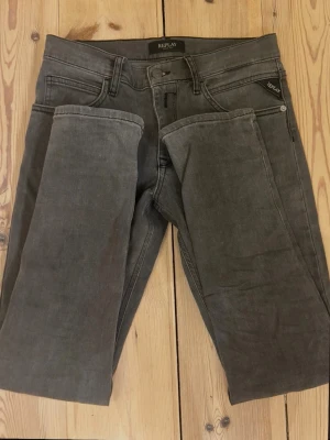 Grå slim fit jeans från Replay - Snygga grå slim fit jeans från Replay med klassisk femficksdesign och dragkedjegylf. Jeansen har en modern passform och är tillverkade i ett mjukt bomullsmaterial med lite stretch för extra komfort. Perfekta till en avslappnad streetwear-look. Nästan nya. 
