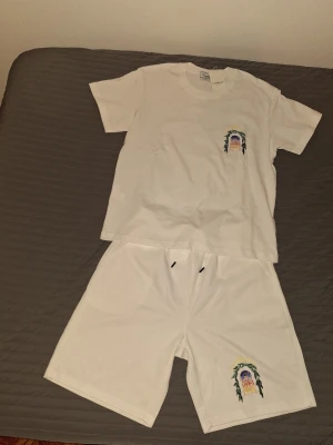Vitt set med tryck från Casablanca  - Säljer ett vitt set från Casablanca med t-shirt och shorts. Båda plaggen har ett färgglatt tryck med motiv av en solnedgång och palmer på bröstet och benet. Säljer den för fick den av en vän men den är för liten så vill sälja den nu. Först till kvarn. Kan sälja dom för bra pris vid snabb affär 