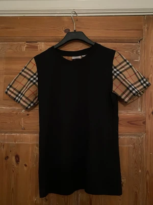 Svart Burberry T-shirt  - Säljer nu min bruberry t shirt står att den är i storlek M på etiketten men skulle säga den sitter mer som XS-S. Kommer i suveränt skick och hade passat för sommaren.