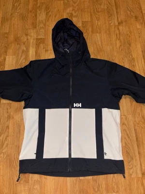 navy blue och vit vindjacka Helly Hansen - Helly Hansen vindjacka som är vattenavvisande i storlek M för män. jackan är oanvänd. pris går att diskutera