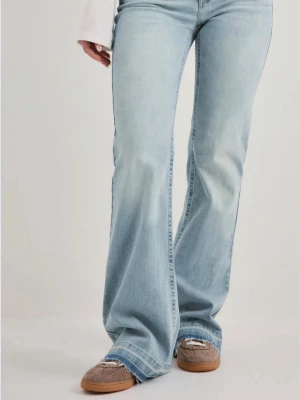 Ljusblå bootcut jeans från Nelly - Säljer ett par ljusblå bootcut jeans med rå, fransad kant nertill. Jeansen har klassisk femficksdesign och hög midja. Tillverkade i mjuk denim med lätt stretch för skön passform. Perfekta för en avslappnad och trendig look.