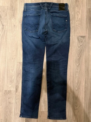 Replay Anbass Hyperflex Jeans Mörkblå W29/L32 - Slim Fit - Replay Anbass Hyperflex mörkblå jeans i stretchig Hyperflex denim med slim fit passform som sitter snyggt och bekvämt och funkar till allt, storlek W29/L32, midja 39 cm, ytterbenslängd 100,5 cm, benöppning 15,5 cm, modellen är 185cm & väger 65kg, i fint skick.