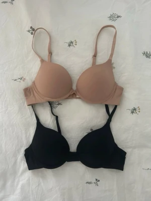 2 Lindex bh  - En beige och en svart bh från Lindex i storlek 75A Jättebra skick, nästan aldrig använda och kommer inte till användning💗 modellen malva  Nypris för en 300 kr