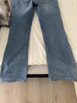 Ljusblå bootcut jeans från ONLY - Säljer ett par ljusblå bootcut jeans från ONLY. Jeansen har klassisk femficksdesign och är tillverkade i denim med lätt tvättad look. Perfekta för dig som gillar en avslappnad och trendig stil.
