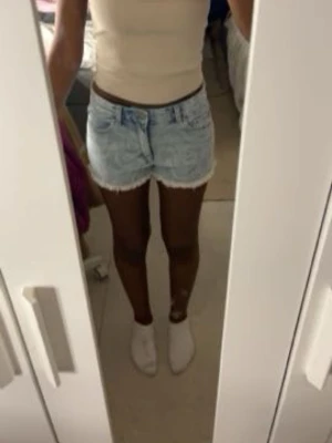 Ljusblå denimshorts med fransig kant - Snygga ljusblå denimshorts med fransig kant nertill. Klassisk femficksmodell med knapp och dragkedja framtill. Perfekta för varma dagar och enkel att matcha med olika toppar. De är helt oanvända.
