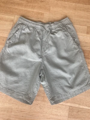Gröna shorts med snörning - Snygga och enkla gröna shorts i bomull/lin med elastisk midja och sidofickor. . Klassisk modell med en bakficka och avslappnad passform.