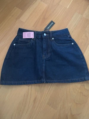Mörkblå jeanskjol från PrettyLittleThing - Snygg mörkblå jeanskjol från PrettyLittleThing, helt oandvänd