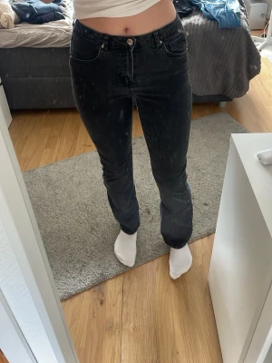 Svarta jeans med hög midja - Säljer ett par svarta jeans med raka ben och hög midja. Jeansen har klassisk femficksdesign och stängs med knapp och dragkedja. Materialet är denim i bomull och de har en stilren look som passar till det mesta. Stor för storleken (164) då jag också är 170cm lång.
