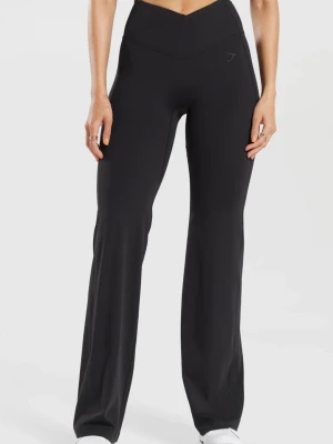 Svarta flared träningsbyxor från Gymshark - Snygga svarta träningsbyxor från Gymshark med flared-modell och hög midja med omlott-detalj. Tillverkade i stretchigt material som sitter skönt och formar sig efter kroppen. Perfekta för dig som vill ha både stil och komfort. Storlek S-regular så passar dig som är ca 163-167 cm.  Har tyvärr klippt bort tvättlappen. 