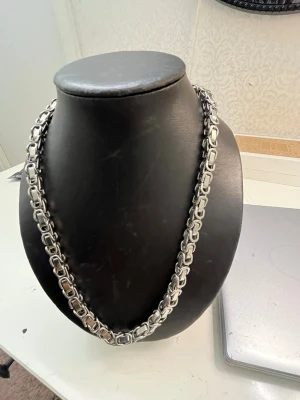 Tungt silverfärgat kedjehalsband - Säljer ett robust halsband i silverfärgad metall med breda, rektangulära länkar som ger en chunky och modern känsla. Perfekt för dig som gillar statement-smycken och vill sticka ut med en cool accessoar.