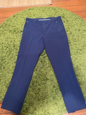 J.Lindeberg golfbyxor - Ett par väl använda marinblå J.Lindeberg golfbyxor i storlek 33/34