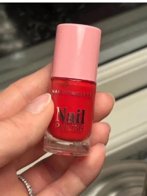 Rött nagellack Makeup Mekka - Snyggt rött nagellack från Makeup Mekka i färgen Holiday Red. Kommer i en liten glasflaska med rosa lock och tydlig etikett. Perfekt för dig som vill ha klassiskt röda naglar med glansig finish.