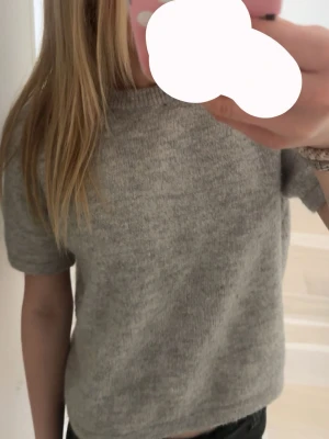 Grå stickad topp - Säljer en enkel grå stickad topp med korta ärmar och croppad passform.