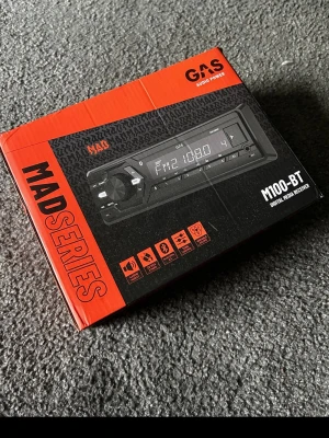 GAS M100-BT bilstereo med Bluetooth - GAS M100-BT är en digital media receiver från MAD Series med Bluetooth, FM-radio och USB-ingång. Svart och röd design, perfekt för att spela musik i bilen och koppla upp mobilen trådlöst. Enkel att använda med tydlig display och flera anslutningsmöjligheter.