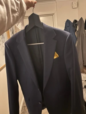 Mörkblå kavaj kostym byxor och vit skjorta - Stilren mörkblå kavaj med klassisk passform, samt mörkblåa kostym byxor och skjorta. Byxor 31-30, kavaj 46 short slim fit. Bägge cotton blend Nypris 3000kr. Skjorta slim fit 37/38 S. Passade mig bra när jag slutade 9an men har vuxit ur den. Endast använd en gång. Näsduck medföljer ej. Notera liten fläck på skjortan. Skriv vid fundering, pris kan diskuteras. 