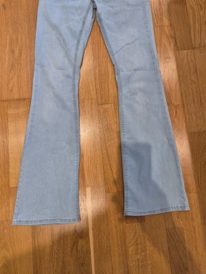 Ljusblå utsvängda jeans från Lindex - Snygga ljusblå jeans med utsvängda ben.. Jeansen har hög midja och är tillverkade i mjukt denimtyg som ger en avslappnad och trendig look.