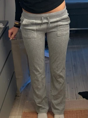 Juicy byxor  - Snygga grå mjukisbyxor med raka ben, bred resår i midjan. Byxorna har två stora fickor framtill och är gjorda i mjukt, bekvämt material som passar perfekt för chill dagar. Enkla att matcha med en hoodie eller crop top.