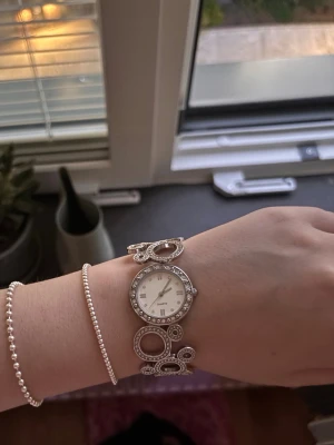 Silverfärgad klocka med cirkeldetaljer - Älskar verkligen den här klockan men kommer tyvärr inte tillräckligt mycket till användning. Osäker på om den fungerar, man kan testa byta batteri eller liknande/lämna in den på ett klockmakeri. Tycker den är otroligt snygg som armband och tycker verkligen att den är ett perfekt statement piece till din outfit. 