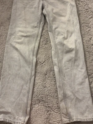Ljusgrå raka jeans - Snygga ljusgrå jeans med rak passform och klassisk femficksdesign. Jeansen har en enkel och stilren look som passar till många olika outfits. Tillverkade i denim med en mjuk känsla. Perfekta för dig som gillar en clean och avslappnad stil.