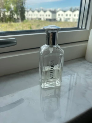 Tommy Hilfiger parfymflaska - 50 ml - Klassisk parfym från Tommy Hilfiger i en genomskinlig glasflaska med silverfärgat lock. Flaskan har en stilren och modern design med märkets logga tryckt på framsidan. Perfekt för dig som gillar fräscha och tidlösa dofter.