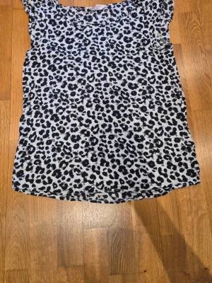Leopardmönstrad topp från H&M - Cool topp från H&M med svart och vit leopardmönster. Modellen är ärmlös och har en avslappnad passform.