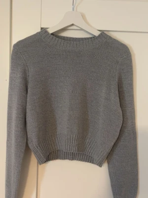 Grå croppad stickad tröja - Snygg grå stickad tröja med croppad passform💕Tröjan är storlek M men skulle säga att den passar mer som storlek S
