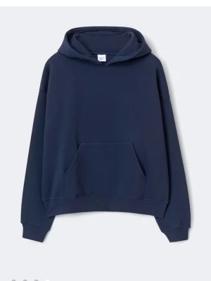 Marinblå Hoodie från Gina tricot - En stilren mörkblå hoodie från Uniqlo i oversized modell. Hoodien har en stor känguruficka framtill, ribbade muddar vid ärmslut och nederkant samt en rejäl huva. Tillverkad i mjuk bomullsblandning som känns skön mot huden.
