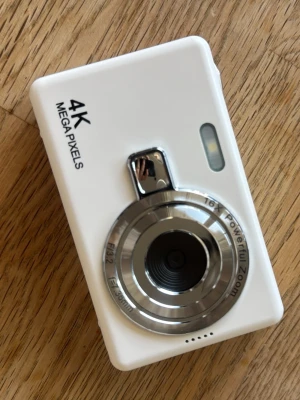 Vit digitalkamera 4K megapixels - Oanvänd,  vit digitalkamera 4K. Kameran har en stor display på baksidan och flera knappar för enkel navigering. 💘Objektivet är i silverfärgad metall och kamerahuset är gjort av plast. Perfekt för dig som vill ta skarpa bilder och filmer. Köpt på Amazon för 378kr, säljs för halva priset 189kr + frakt🎀 Kommer i orginalförpackningen!🔥
