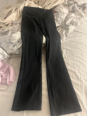 Svarta bootcut trännings tights från OTP - Säljer ett par svarta bootcut tights från OTP med hög midja. Tightsen är i stretchigt material och har en snygg utsvängd passform nertill, perfekta för träning eller chill. Diskret logga framtill i midjan. Använt ca 2 ggr dom är gjorda för korta som är runt 160