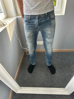 Jack&jones jeans med slitningar - Snygga slim fit jeans i ljusblå denim med slitningar och hål på framsidan. Jeansen har klassisk femficksdesign, normal midja och är tillverkade i bomull med lite stretch för skön passform. Perfekta för en avslappnad och trendig look.