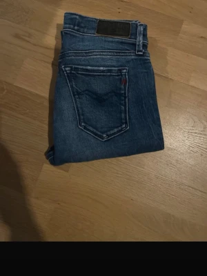 Mörkblå jeans från replay -  Snygga mörkblå skinny jeans från Replay med klassisk femficksdesign och diskreta slitningar. Jeansen har en smal passform och är tillverkade i stretchigt denim för extra komfort. Perfekta till vardagslooken.