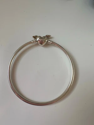 Silverfärgat armband med hjärta och vingar - Vingarna är silvriga det blev bara mitt rosa mobilskal som speglas, om du är osäker kan du skriva till mig💞